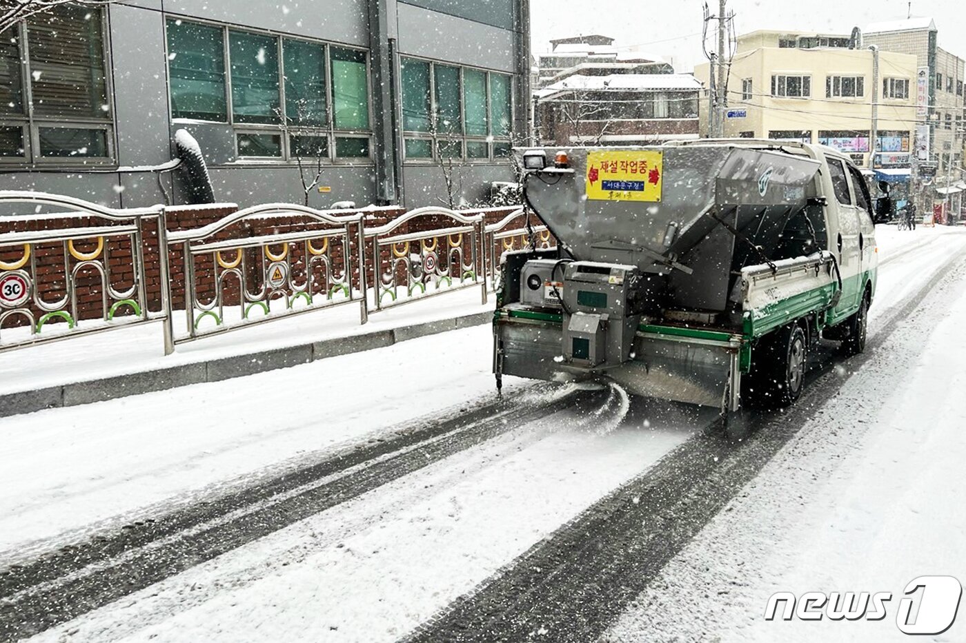 본문 이미지 - 수도권 일부 지역에 대설주의보가 발효된 18일 서울 서대문구 일대에서 구청 관계자들이 차량을 이용해 염화칼슘을 살포하고 있다.(서대문구청 제공) 2021.12.18/뉴스1 ⓒ News1