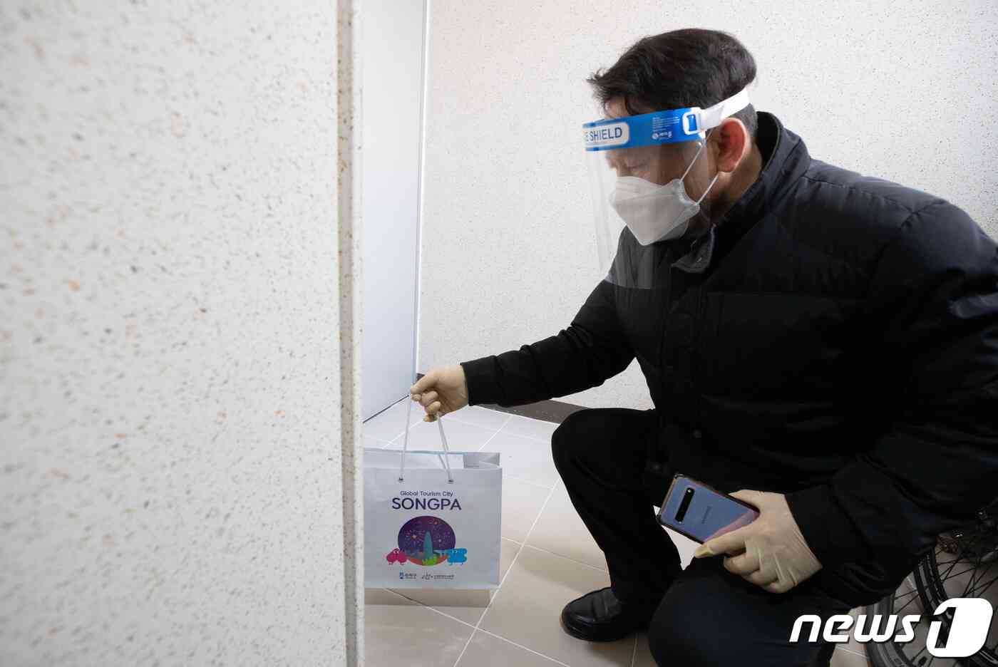 신종 코로나바이러스 감염증(코로나19) 신규 확진자가 5266명 발생한 2일 오전 서울의 한 아파트에서 송파구청 코로나19 재택치료 전담팀 직원이 재택치료자 문 앞에 건강관리키트를 놓고 있다. 확진자가 늘면서 신규 재택 치료자가 처음으로 1000명을 넘어섰다. 2021.12.2/뉴스1 © News1 이재명 기자