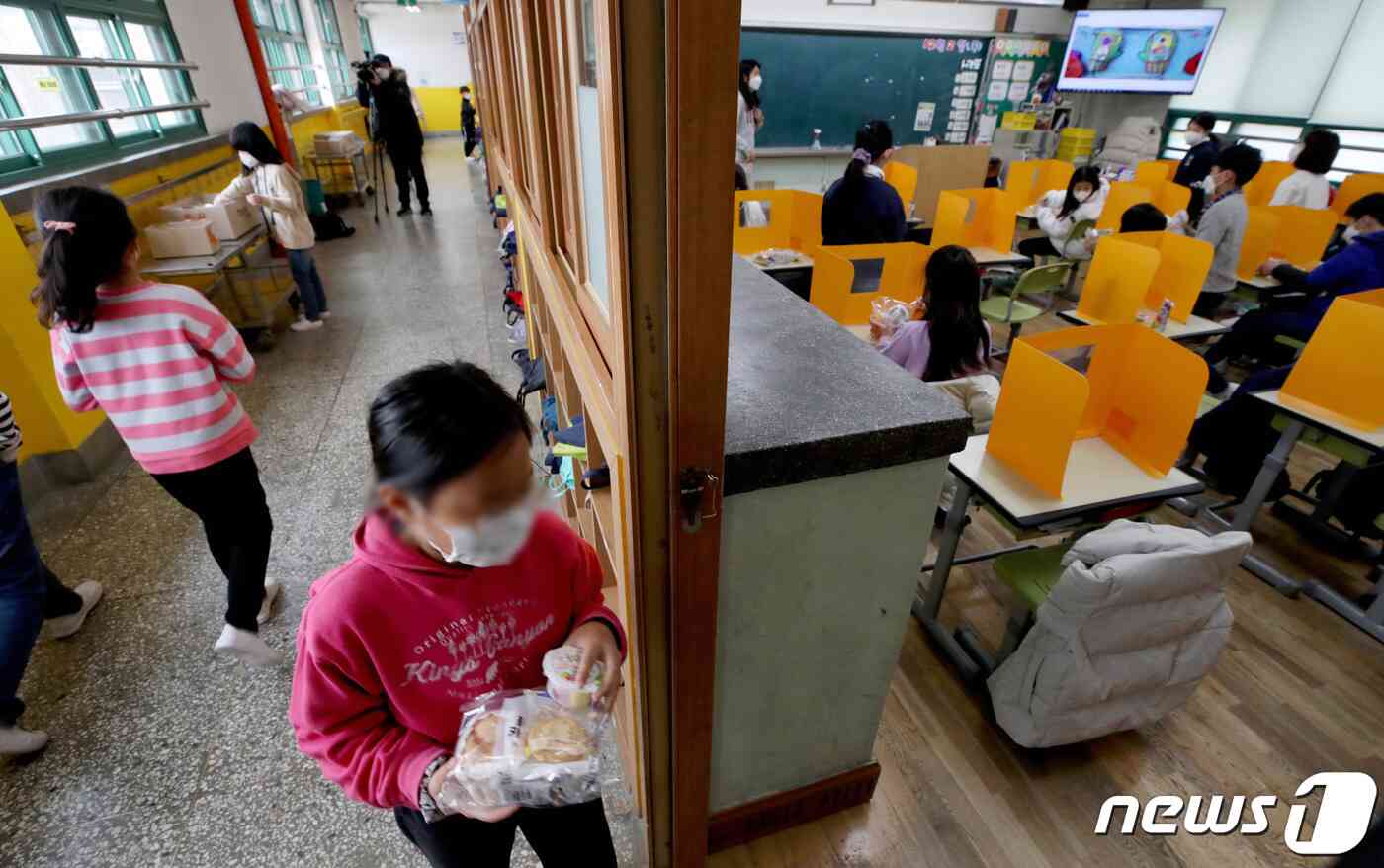 급식과 돌봄 등을 책임지는 학교 비정규직 노동자들이 처우개선을 촉구하며 2차 총파업에 돌입한 2일 서울 한 초등학교에서 학생들이 대체식으로 준비된 빵과 과일, 주스 등을 배식 받고 있다. 2021.12.2/뉴스1 © News1 박정호 기자