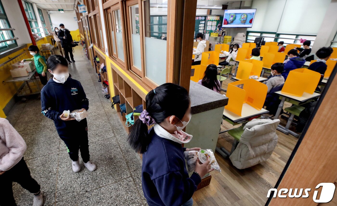 본문 이미지 - 급식과 돌봄 등을 책임지는 학교 비정규직 노동자들이 처우개선을 촉구하며 2차 총파업에 돌입한 2일 서울 한 초등학교에서 학생들이 대체식으로 준비된 빵과 과일, 주스 등을 배식 받고 있다. 2021.12.2/뉴스1 ⓒ News1 박정호 기자