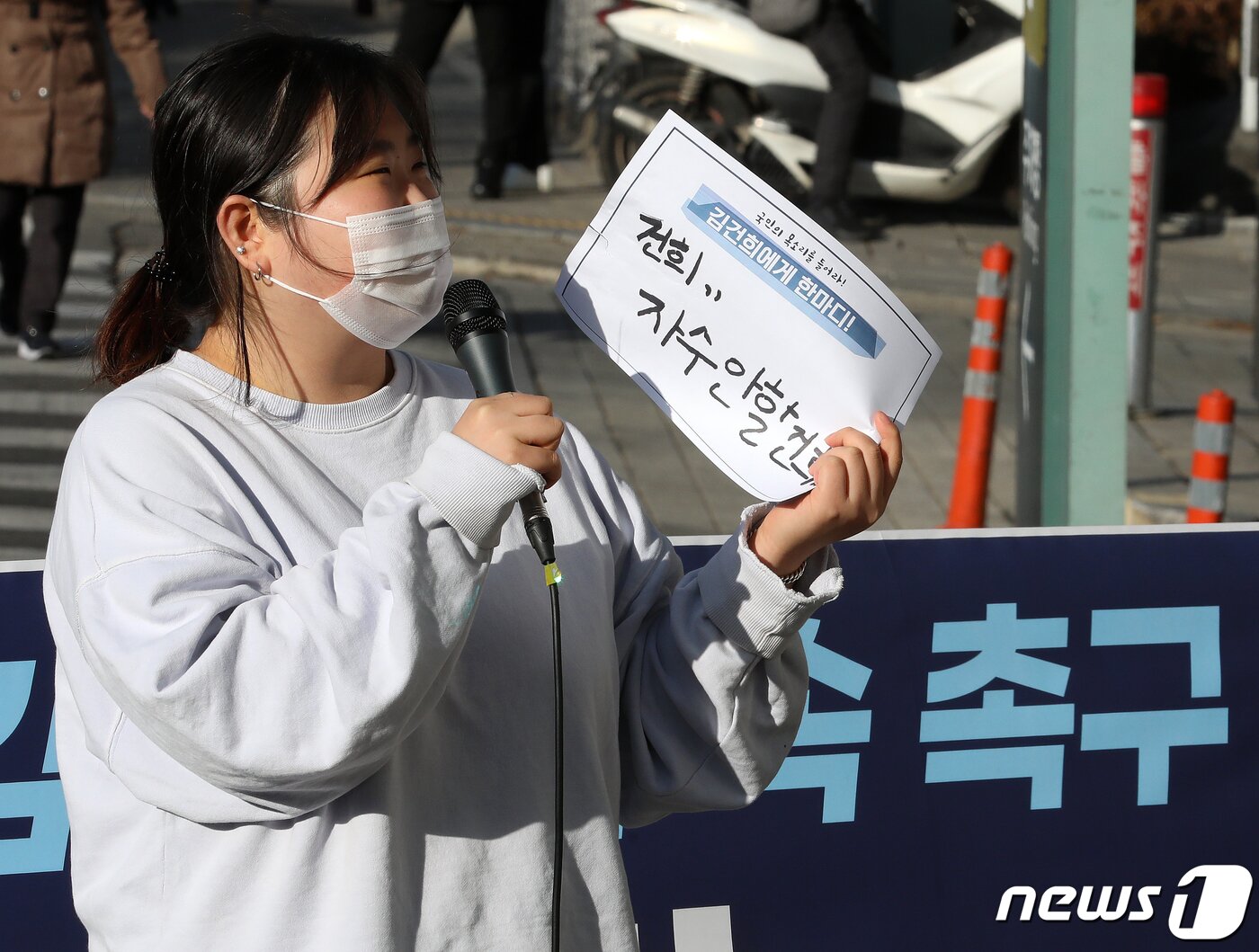 본문 이미지 - 대학생 대선실천단 학생이 22일 오후 서울 서초구 서초동 아크로비스타 앞에서 열린 ‘허위경력은 범죄다! 김건희는 자수하라!’ 구속 촉구 집회에서 김건희에게 적은 한마디의 피켓을 들며 모두발언을 하고 있다. 2021.12.22/뉴스1 ⓒ News1 김진환 기자