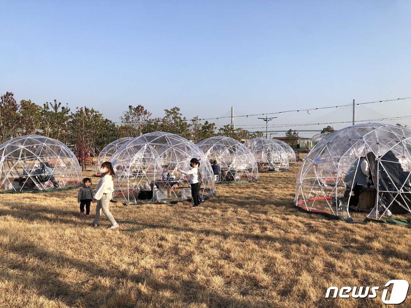 본문 이미지 - 23일 개방된 부산 동구 부산항 국제여객터미널 인근 문화공원 1호에 설치된 투명이글루에서 아이들이 뛰놀고 있다.2021.12.23/ⓒ 뉴스1 백창훈 기자