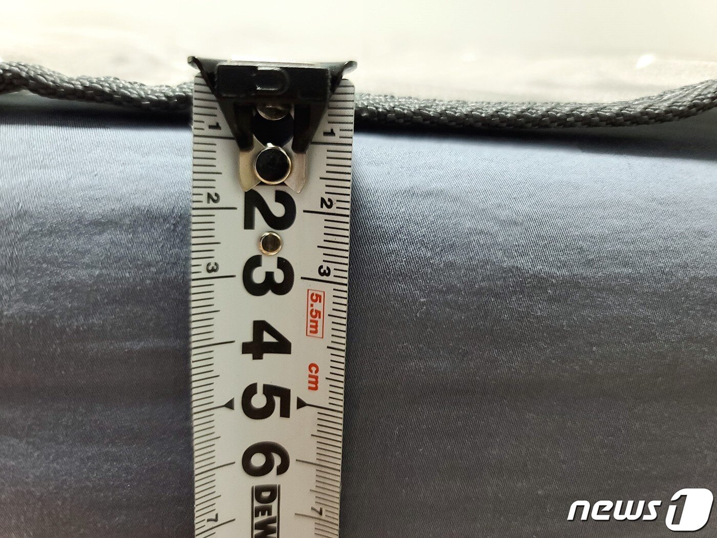 본문 이미지 - 경동나비엔 온수매트 THE CARE EQM541 두께. 직접 줄자를 이용해 측정해본 결과, 1cm도 되지 않을 정도로 얇은 모습. ⓒ 뉴스1 조현기 기자