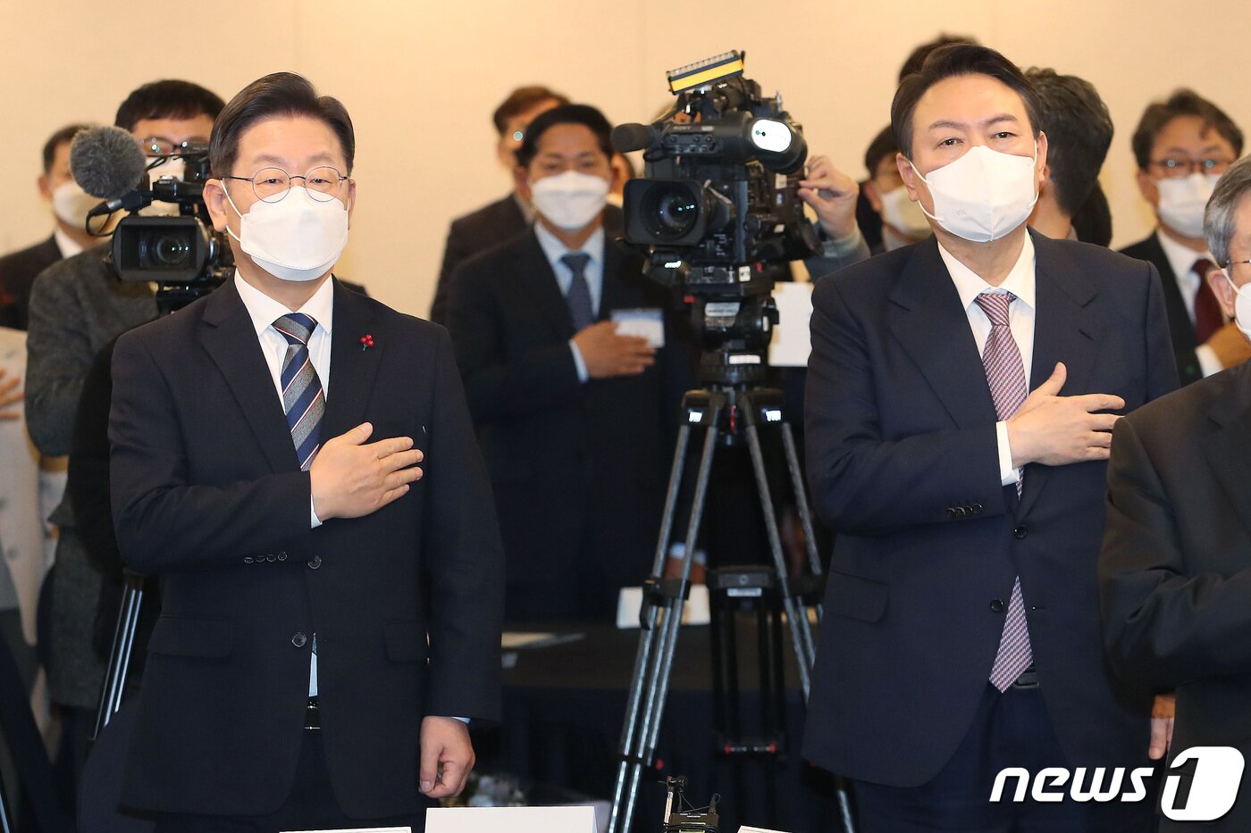 본문 이미지 - 이재명 더불어민주당 대선 후보와 윤석열 국민의힘 대선 후보가 27일 오후 서울 중구 프레스센터에서 한국지방신문협회 주최로 열린 지방자치대상 및 한국지역발전대상 시상식에 국민의례를 하고 있다. 2021.12.27/뉴스1 ⓒ News1 국회사진취재단