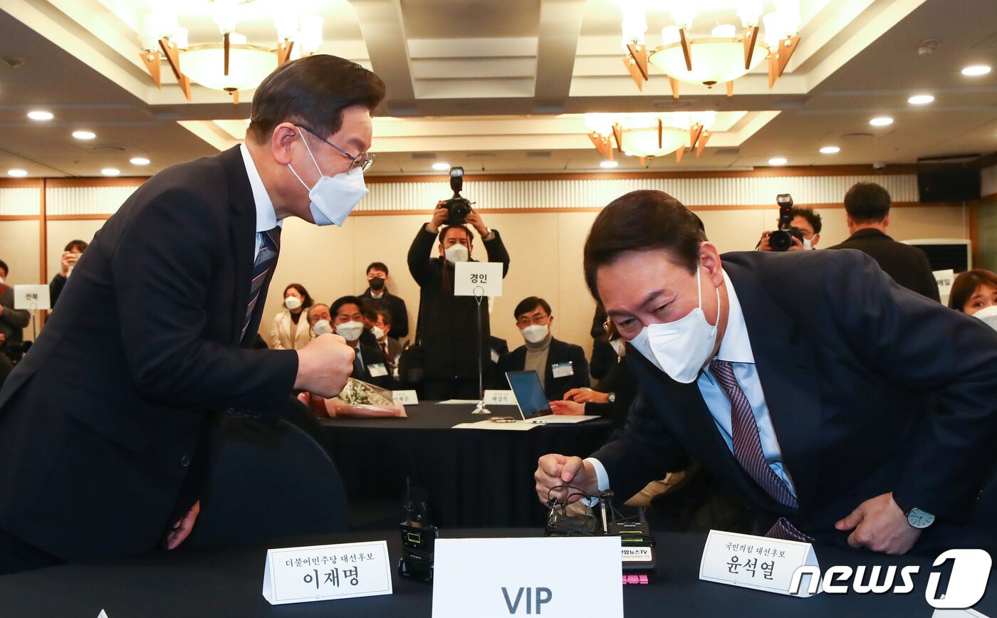 본문 이미지 - 이재명 더불어민주당 대선 후보와 윤석열 국민의힘 대선 후보가 27일 오후 서울 중구 한국프레스센터에서 열린 지방자치대상 및 한국지역발전대상 시상식에서 만나 인사 나눈 뒤 자리에 앉고 있다. 2021.12.27/뉴스1 ⓒ News1 국회사진취재단