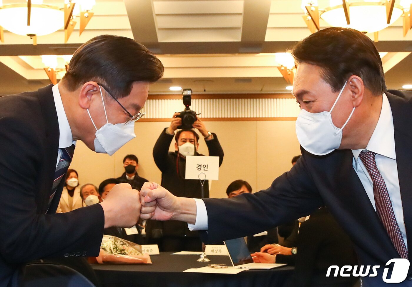 본문 이미지 - 이재명 더불어민주당 대선 후보와 윤석열 국민의힘 대선 후보가 27일 오후 서울 중구 한국프레스센터에서 열린 지방자치대상 및 한국지역발전대상 시상식에서 만나 주먹인사를 나누고 있다. 2021.12.27/뉴스1DB