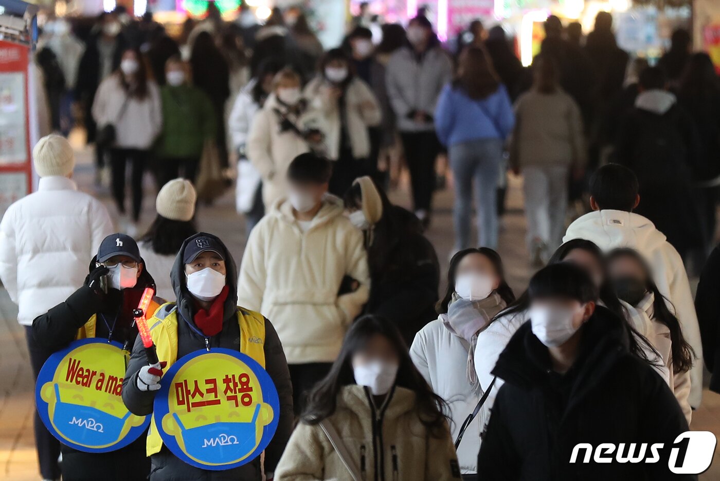 본문 이미지 - 단계적 일상회복 시행 약 한 달 만에 코로나19 방역지침이 다시 강화된다. 중앙재난안전대책본부 등에 따르면 오는 6일부터 수도권의 사적모임 허용 인원이 10명에서 6명으로 줄어든다. 식당·카페 등 실내 다중이용시설과 야외 공연장, 박물관 등에는 방역패스 적용이 확대된다. 3일 오후 서울 마포구 홍익대학교 주변 번화가에서 북적이는 시민들 사이로 마포구청 관계자들이 마스크 착용 캠페인을 벌이고 있다. 2021.12.3/뉴스1 ⓒ News1 민경석 기자
