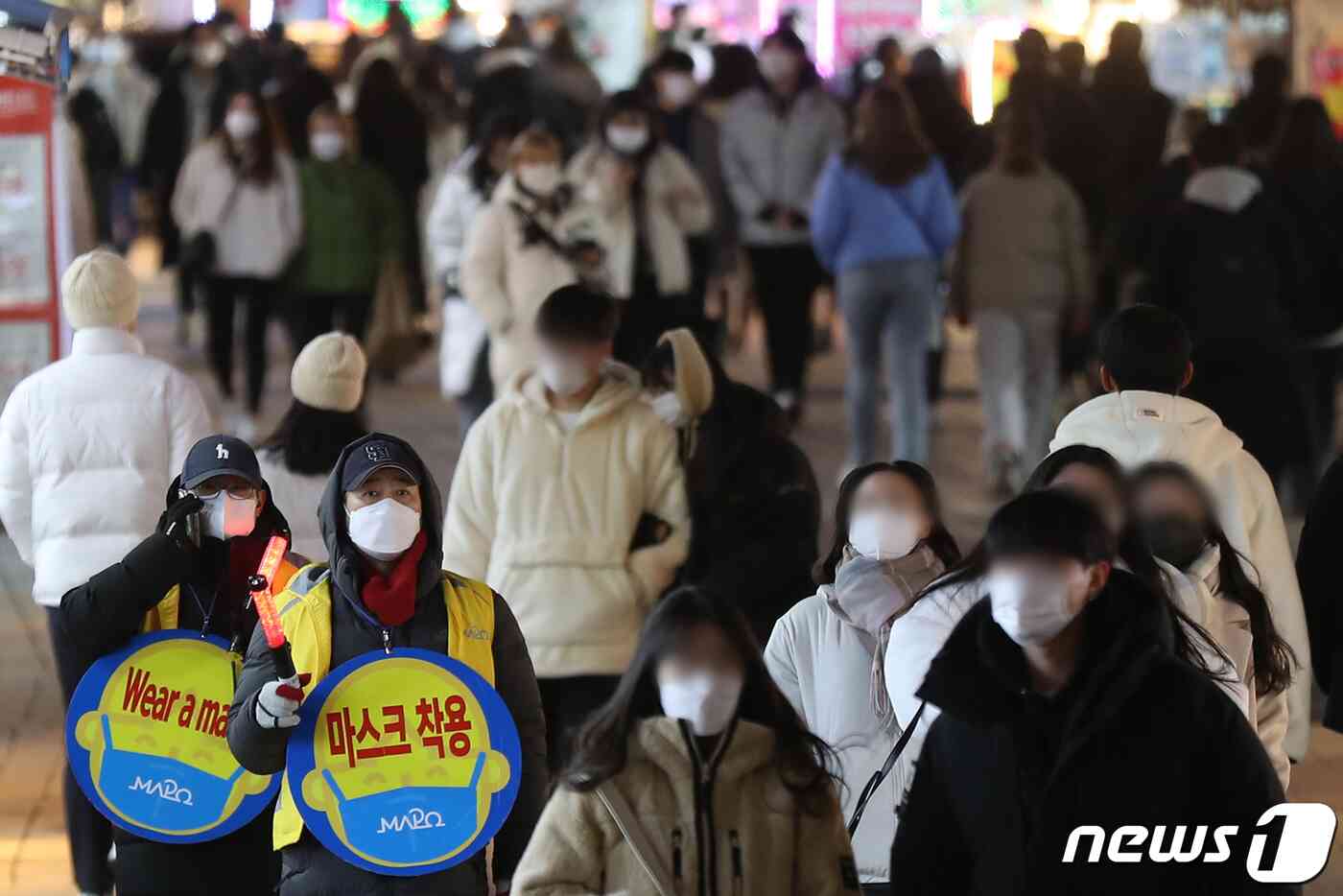 단계적 일상회복 시행 약 한 달 만에 코로나19 방역지침이 다시 강화된다. 중앙재난안전대책본부 등에 따르면 오는 6일부터 수도권의 사적모임 허용 인원이 10명에서 6명으로 줄어든다. 식당·카페 등 실내 다중이용시설과 야외 공연장, 박물관 등에는 방역패스 적용이 확대된다. 3일 오후 서울 마포구 홍익대학교 주변 번화가에서 북적이는 시민들 사이로 마포구청 관계자들이 마스크 착용 캠페인을 벌이고 있다. 2021.12.3/뉴스1 © News1 민경석 기자
