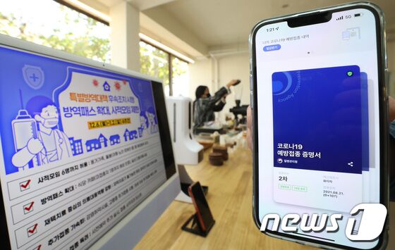 사적모임 인원 축소, 방역패스 확대 등 특별방역대책 시행이 시작된 6일 오후 경기도 수원시 팔달구의 한 카페에 관련 내용이 적힌 안내문이 게시되어 있다. 이날부터 사적모임에서 수도권은 6명, 비수도권은 8명밖에 모이지 못하고 방역패스가 적용되는 업종이 기존 5개에서 식당, 카페 등 포함 16개로 확대됐다. 2021.12.6/뉴스1 © News1 김영운 기자