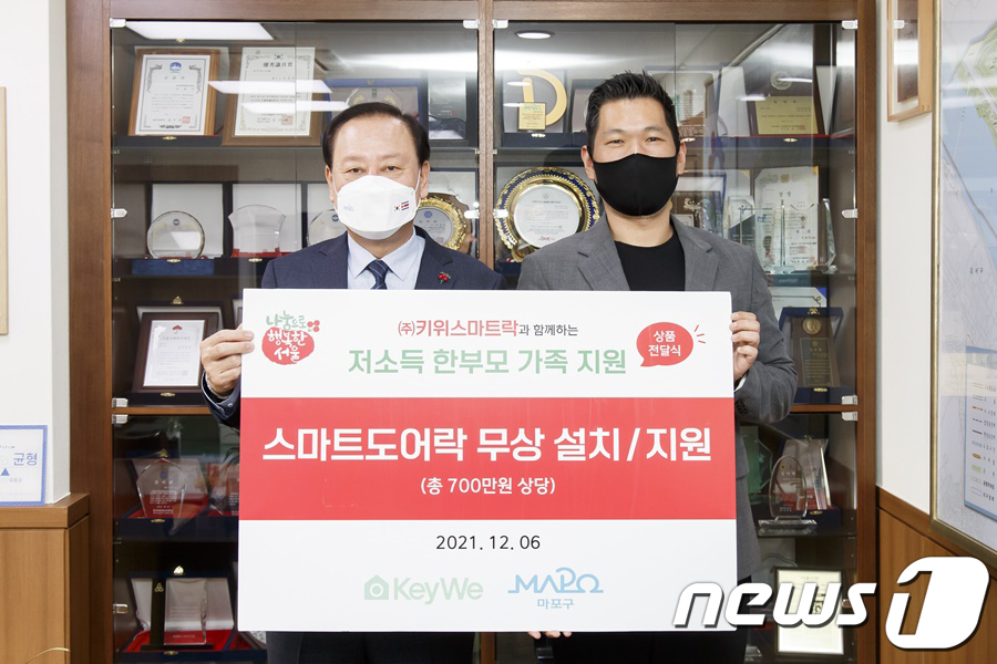 (서울=뉴스1) 김명섭 기자 = 김도현 ㈜키위 스마트락 대표가 6일 오후 서울 마포구청에서 유동균 구청장에게 스마트도어락 32개를 전달하고 있다. 총 700만원 상당의 스마트도어락 …