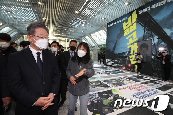 이재명 더불어민주당 대선 후보가 8일 오후 국회 의원회관 3층 전시공간에서 고 김용균 3주기 추모 사진전을 살펴보고 있다. 사진전은 변백선, 윤성희, 이명익, 정택용, 최형락 사진가가 참여했다. 2021.12.8/뉴스1 © News1 이동해 기자