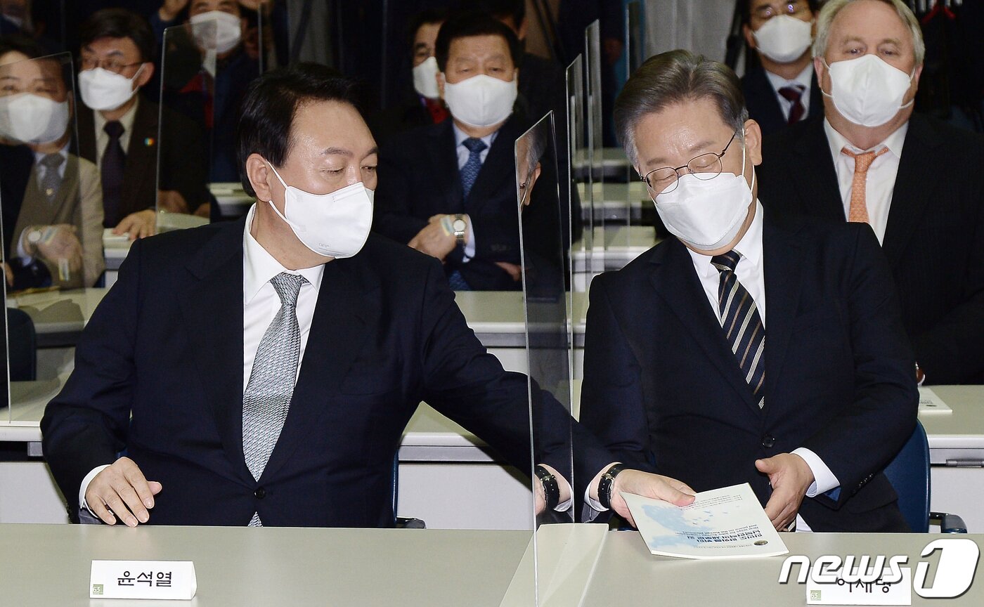 본문 이미지 - 9일 오후 서울 마포구 연세대학교 신촌캠퍼스 김대중도서관에서 열린 김대중 대통령 노벨평화상 수상 21주년 기념식에서 윤석열 국민의힘 대선후보가 이재명 더불어민주당 대선후보에게 기념식과 관련한 안내책자를 전해주고 있다. 2021.12.9/뉴스1 ⓒ News1 국회사진취재단