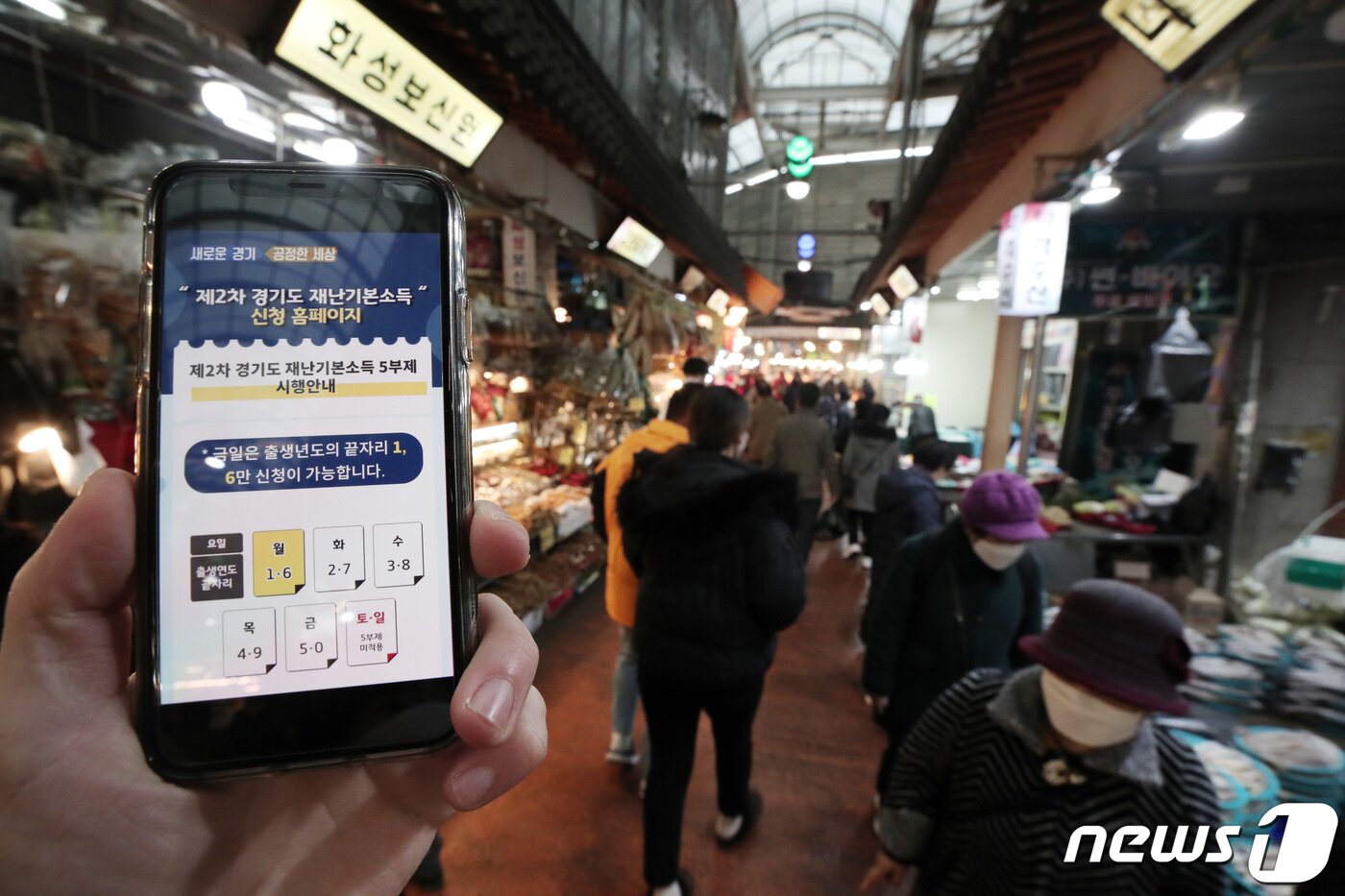 본문 이미지 - 경기도 2차 재난기본소득 신청 첫날인 1일 오전 경기도 수원시 못골시장을 찾은 시민들이 물품을 구매하고 있다. 2차 재난기본소득은 코로나19 확산 방지를 위해 온라인 신청, 현장 수령, 찾아가는 신청서비스 등 3가지 방법으로 지급된다. 2021.2.1/뉴스1 ⓒ News1 조태형 기자