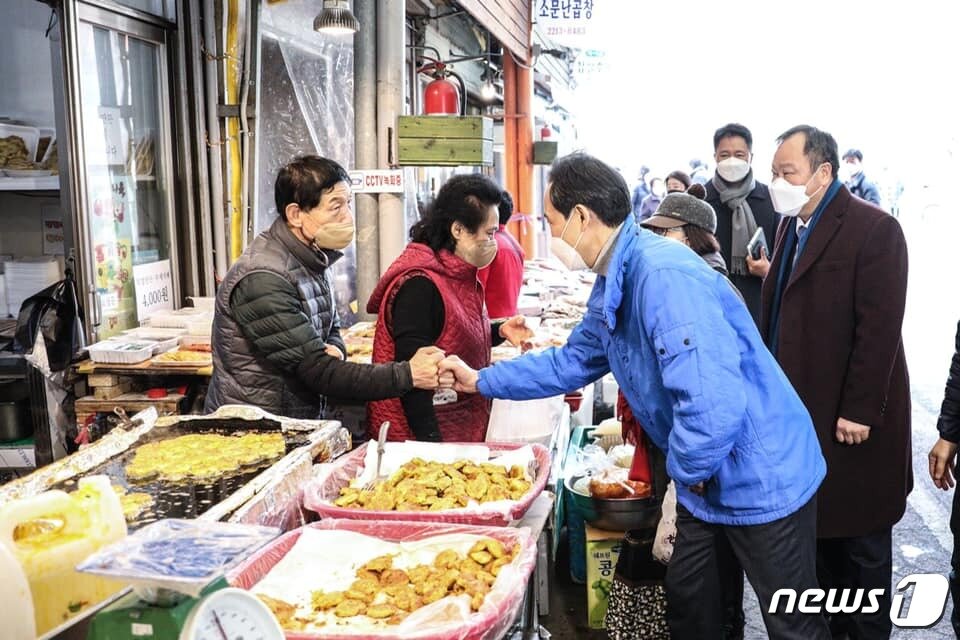 본문 이미지 - 11일 서울 동대문 현대시장을 방문한 우상호 더불어민주당 서울시장 예비후보가 상인들과 주먹인사를 하고 있는 모습(우상호 예비후보 페이스북). ⓒ 뉴스1