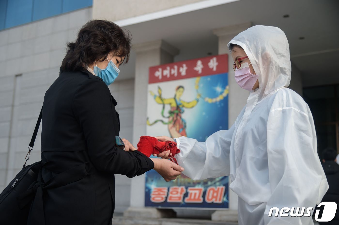 본문 이미지 - 작년 11월16일 북한 평양교예극장 입구에서 한 여성이 발열 검사를 받고 있다. ⓒ AFP=뉴스1