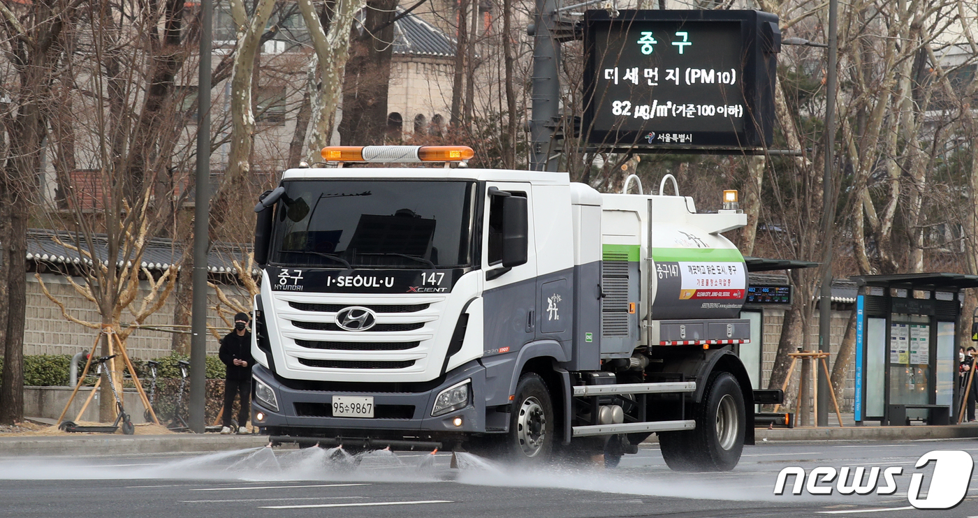 (서울=뉴스1) 김명섭 기자 = 초미세먼지 나쁨을 보인 14일 오전 서울 세종대로 일대에서 분진흡입차와 물청소차가 미세먼지 비상저감조치 발령에 따른 도로 분진 청소를 하고 있다. …