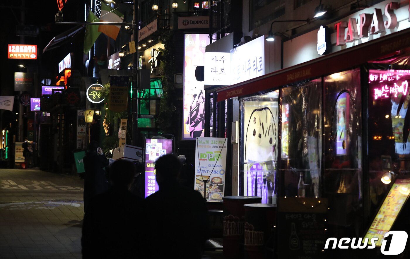 본문 이미지 - 수도권의 사회적 거리두기가 2단계로 완화된 15일 저녁 서울 용산구 이태원 거리에 불 켜진 간판 사이로 시민들이 지나가고 있다./뉴스1 ⓒ News1 이동해 기자