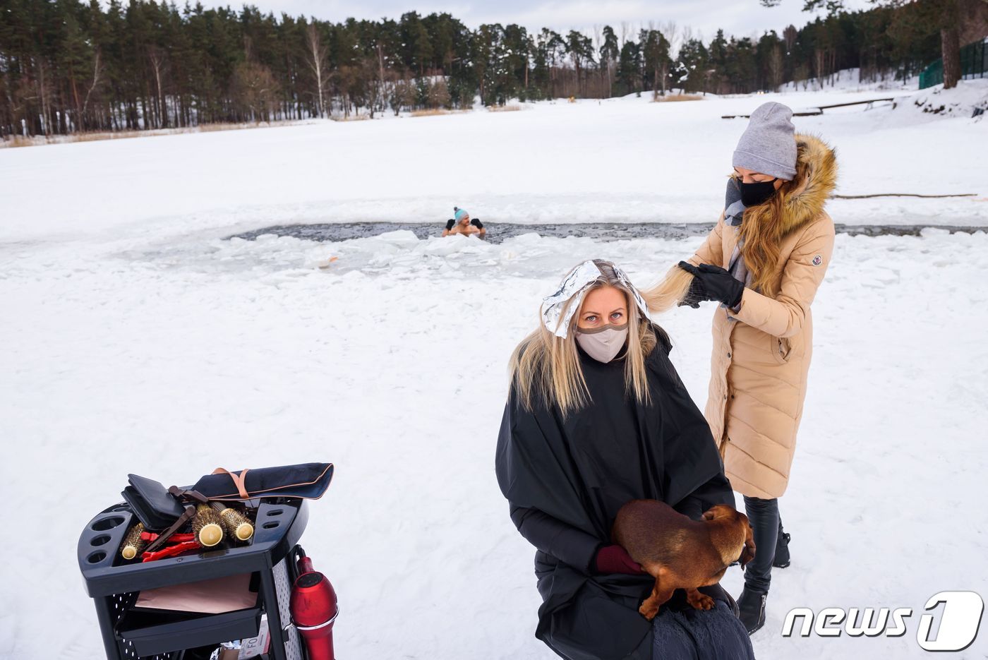 (리가 AFP=뉴스1) 우동명 기자 = 15일(현지시간) 코로나19 확산으로 영업을 하지 못하는 미용사가 라트비아 수도 리가 인근의 꽁꽁 얼어붙은 호수가에서 여성의 머리를 자르고 …