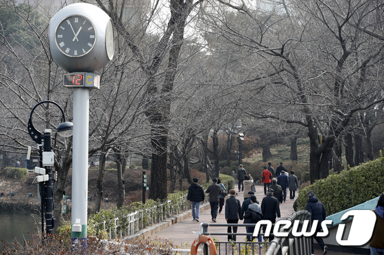 22일 오후 서울 송파구 석촌호수에서 시민들이 산책을 하고 있다. 2021.2.22/뉴스1 © News1 이승배 기자