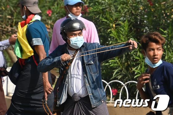 미얀마 양곤 등지에서 2021년 2월 25일 군정 지지자들이 등장해 새총과 칼, 파이프 등을 사용하며 시위대와 충돌했다. © AFP=뉴스1 