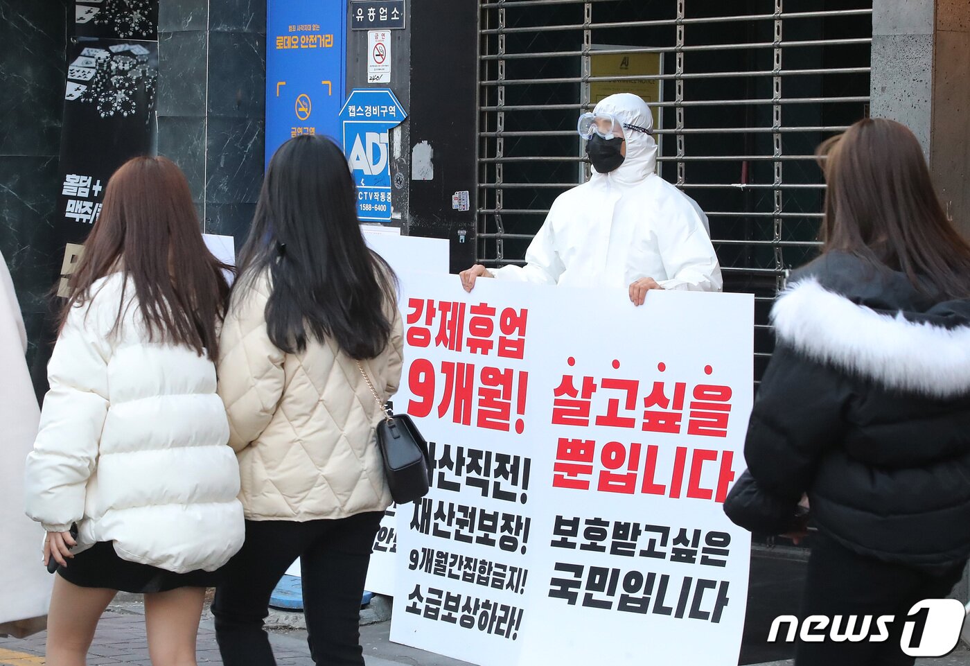본문 이미지 - 3일 오후 대구 중구 동성로의 한 클럽 앞에서 방역복을 입은 클럽 관계자가 1인 시위를 하고 있다. 코로나19로 인해 반복되는 집합금지 명령과 강제휴업에 심각한 경제적 위기를 겪고 있는 상인들의 피해보상을 촉구하기 위한 이날 1인 시위는 동성로 클럽골목 6개 클럽에서 진행됐다. 2021.2.3/뉴스1 ⓒ News1 공정식 기자