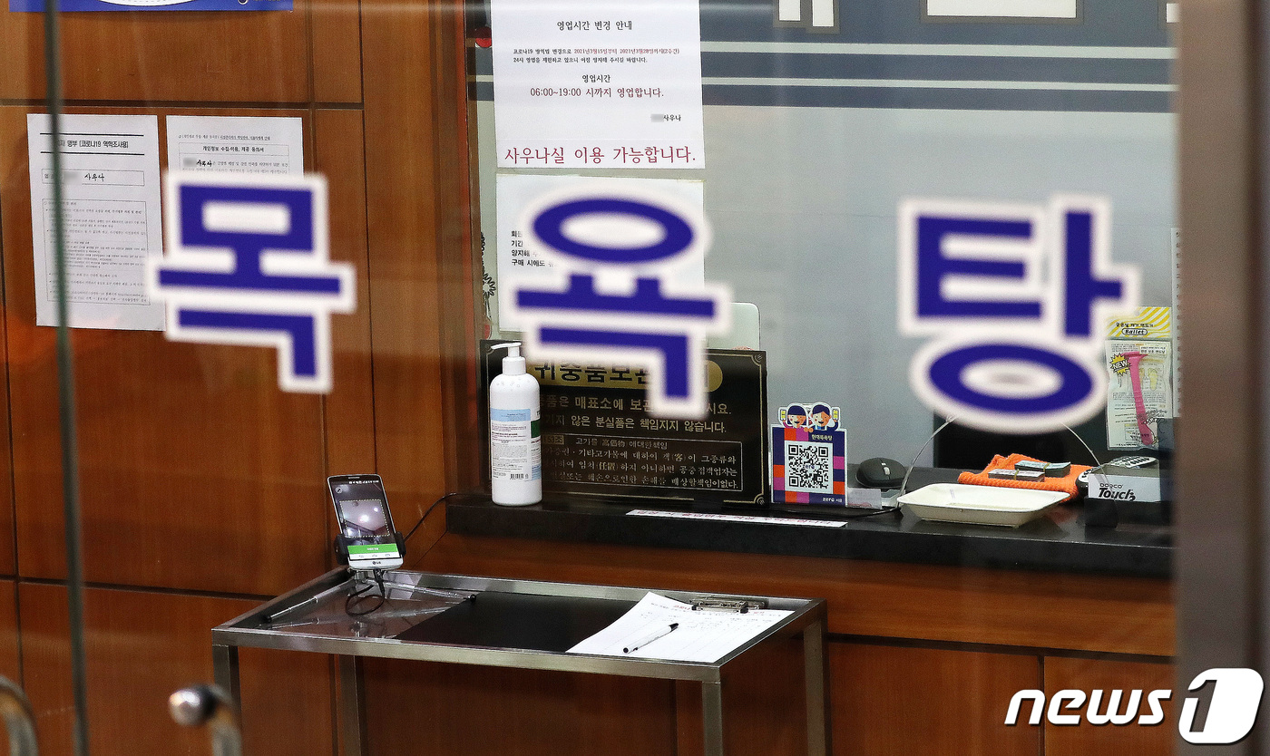 (서울=뉴스1) 박지혜 기자 = 목욕장업 전자출입명부 사용이 의무화된 16일 서울의 한 목욕탕에 전자출입명부와 수기로 작성하는 출입명부가 놓여 있다.지난 15일부터 목욕탕 내 사우 …