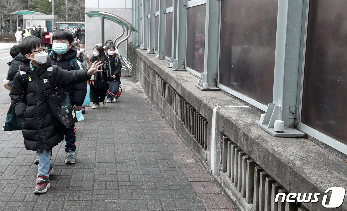 (수원=뉴스1) 조태형 기자 = 2021학년도 신학기 등교가 시작된 2일 오전 경기도 수원시 매여울초등학교에서 한 신입생이 교실로 향하며 담장 밖 부모님에게 인사하고 있다. 202 …