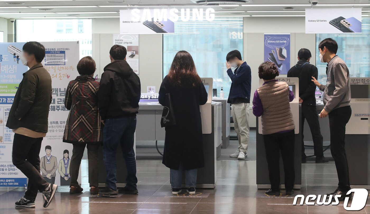 본문 이미지 - 구글 안드로이드 운영체제(OS)를 이용하고 있는 스마트폰 앱 실행 오류가 발생한지 하루가 지난 24일 서울 중구의 한 삼성전자서비스센터에서 고객들이 서비스 접수를 하고 있다. 2021.3.24/뉴스1 ⓒ News1 임세영 기자