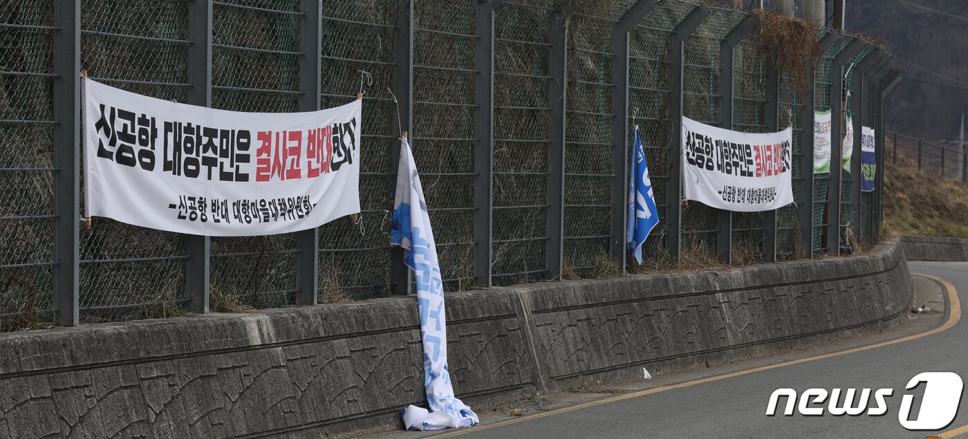 본문 이미지 - 4일 오전 부산 강서구 대항동 대항전망대에 신공항 건설 반대 문구가 적힌 현수막이 걸려 있다. 반대 문구 사이에는 가덕도신공항 특별법 통과를 환영하는 현수막이 찢어져 있다.021.3.4 /뉴스1 ⓒ News1 여주연 기자