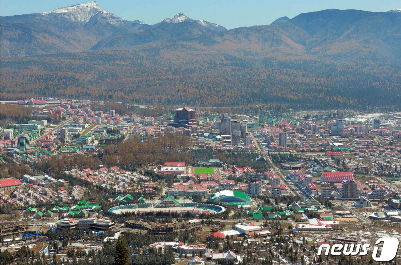 본문 이미지 - 새롭게 개발되고 있는 삼지연시 전경. 뒤쪽으로 북포태산이 솟아 있고, 사진의 왼쪽 제일 위의 붉은 지붕 건물이 새로 건설된 삼지연청년역이다. 혜산-삼지연 철도는 2015년에 착공돼 2019년 10월에 완공됐다. 2021.03.06.ⓒ 뉴스1
