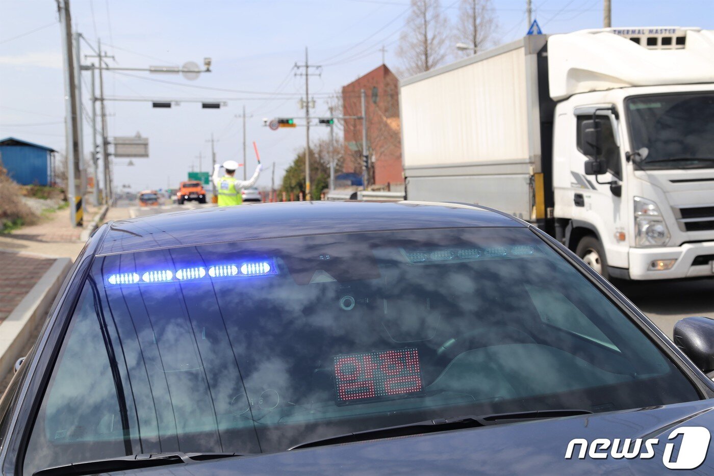 본문 이미지 -  전북경찰청이 새로 도입한 '암행순찰차'인 제네시스 G70  앞 모습. 1일 오후 전북 김제시 백구면 26번 국도 위에서 전북경찰청 암행순찰팀 박명식 경위가 신호위반 차량을 적발하고 사건을 처리하는 동안 파트너 경찰관인 전경노 경장이 능숙하게 다른 차량들을 안전하게 지도하고 있다. 2021.4.1/ⓒ 뉴스1 이지선기자