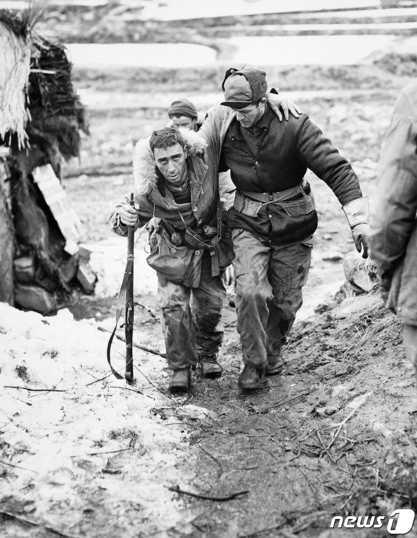 본문 이미지 - 1951년 4월 '가평전투' 직후 캐나다군 '패트리샤 공주 경보병연대'(PPCLI) 제2대대 소속 윌리엄 크라이슬러 병장(오른쪽)이 부상당한 동료를 부축해 이동하는 모습을 촬영한 사진 (영국 제국전쟁박물관 소장품) (전쟁기념관 제공) ⓒ 뉴스1