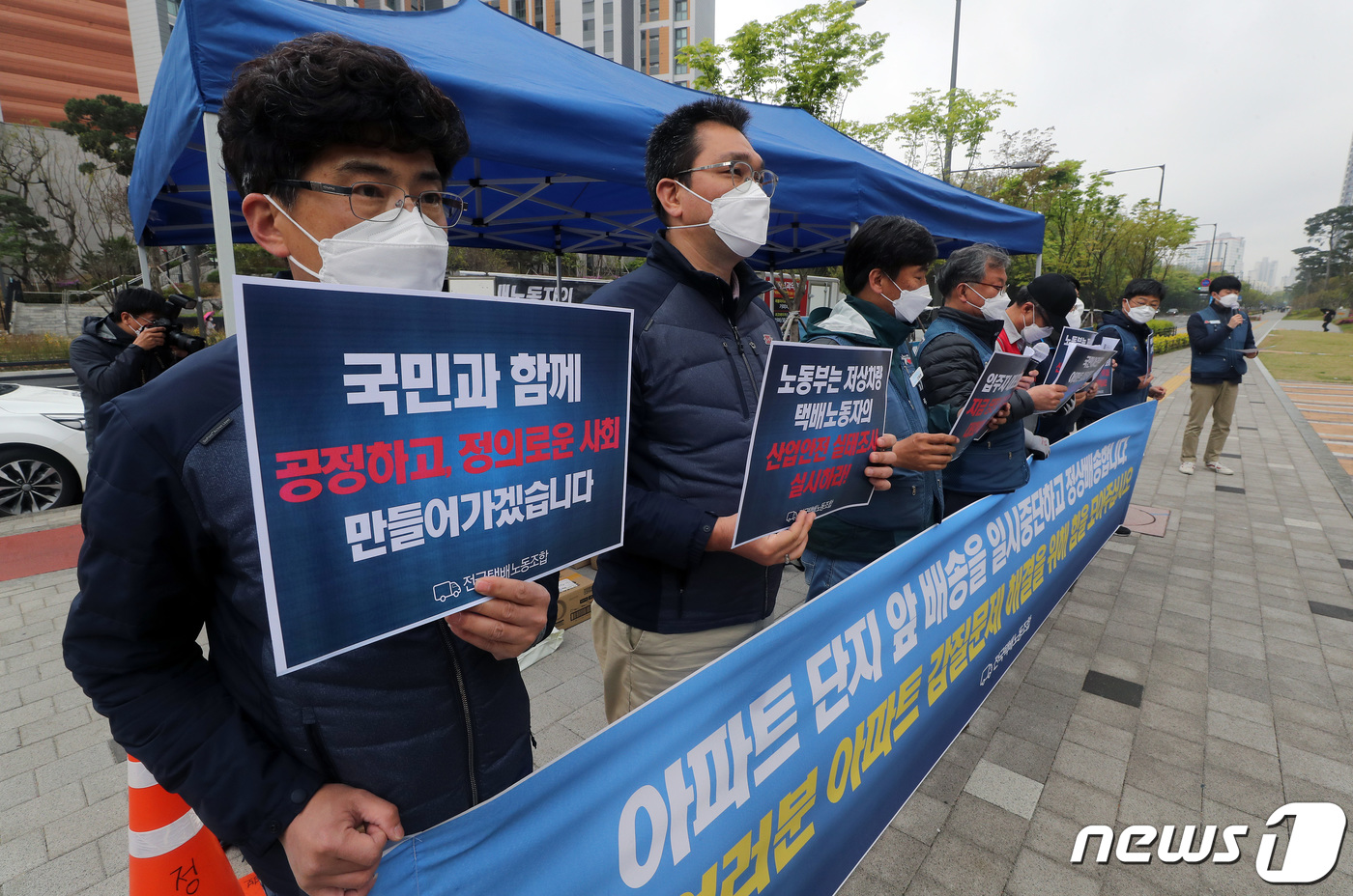 (서울=뉴스1) 이동해 기자 = 전국택배노동조합 관계자들이 16일 오후 단지 내 택배차량 진입이 제한된 서울 강동구 고덕동에 위치한 5000세대 규모 아파트 앞에서 열린 기자회견에 …