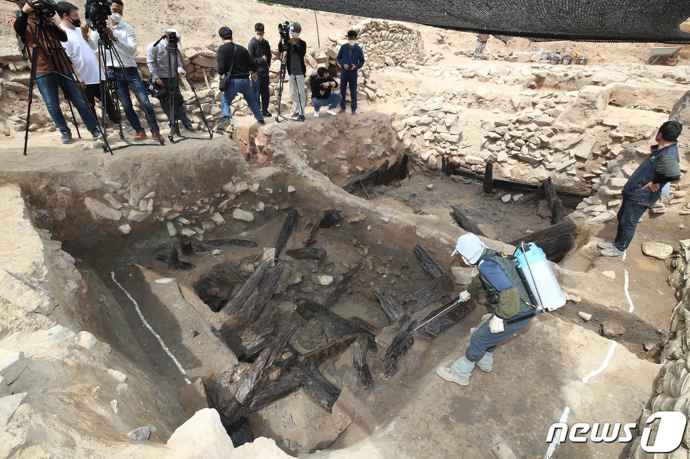 지난해 4월 대구 북구 노곡동 함지산 팔거산성에서 화랑문화재연구원 관계자들이 7세기 초반 신라시대 목간이 출토된 집수지 주변 발굴 현장에서 수분을 유지하기 위해 목재에 물을 뿌려 관리하는 모습. &#40;뉴스1 DB&#41; /뉴스1 ⓒ News1 공정식 기자