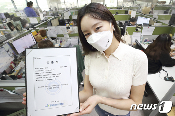 서울 동작구에 위치한 KT 콜센터에서 모델이 KT AICC의 클라우드 보안 인증서를 보여주고 있다. (KT 제공) © 뉴스1
