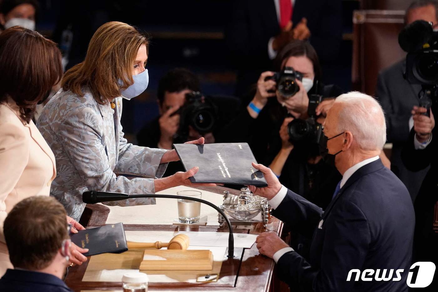 본문 이미지 - 조 바이든 미국 대통령이 2021년 4월28일(현지시간) 워싱턴 의사당에서 취임 후 첫 상·하원 합동 연설에 도착해 카멀라 해리스 부통령과 낸시 펠로시 하원의장에게 연설문 복사본을 주고 있다. ⓒ AFP=뉴스1 ⓒ News1 우동명 기자