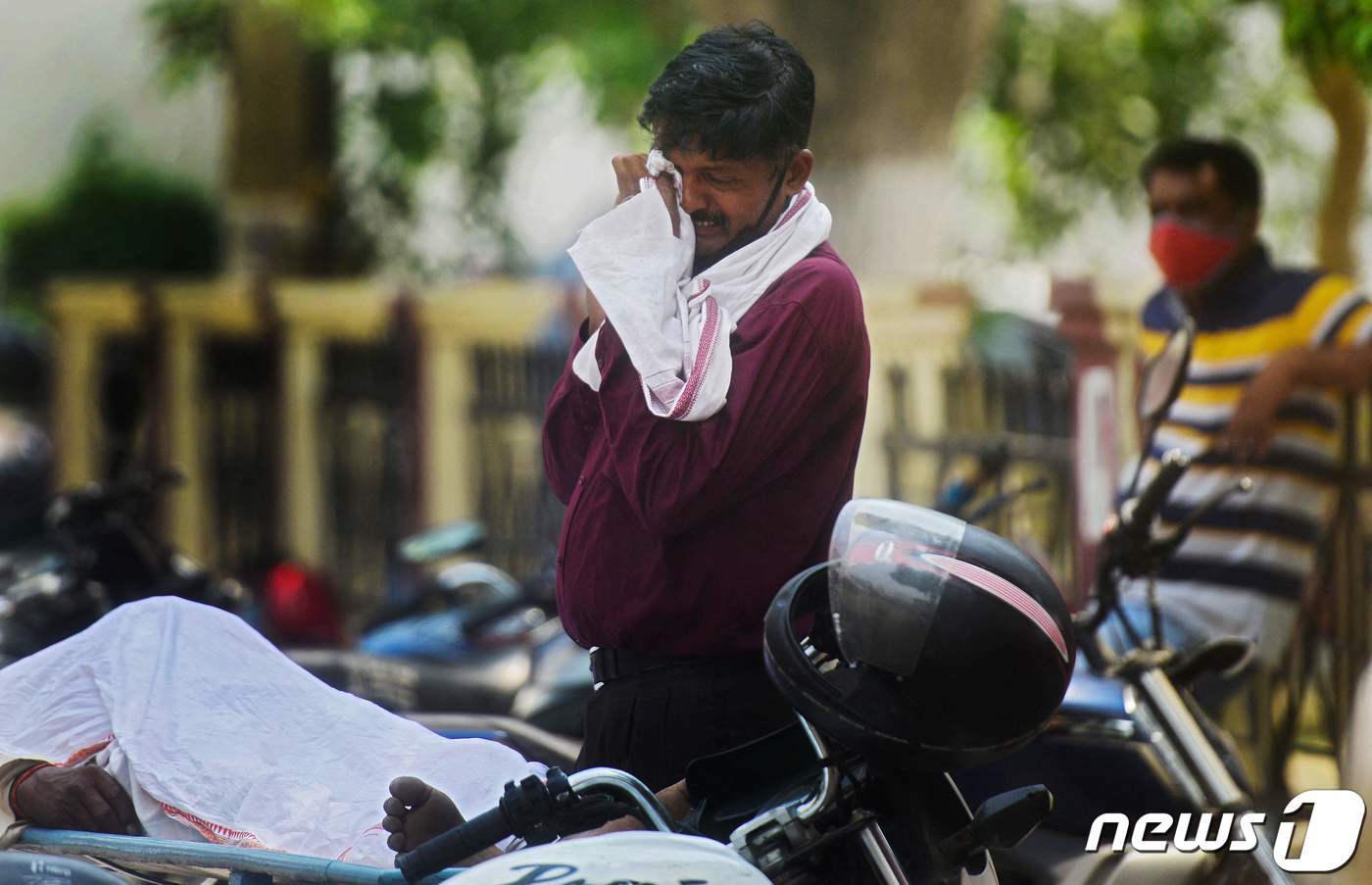 본문 이미지 - 코로나19 유행이 한창이던 2021년 4월 인도 거리에서 친지의 죽음을 슬퍼하는 남성의 모습. ⓒ AFP=뉴스1