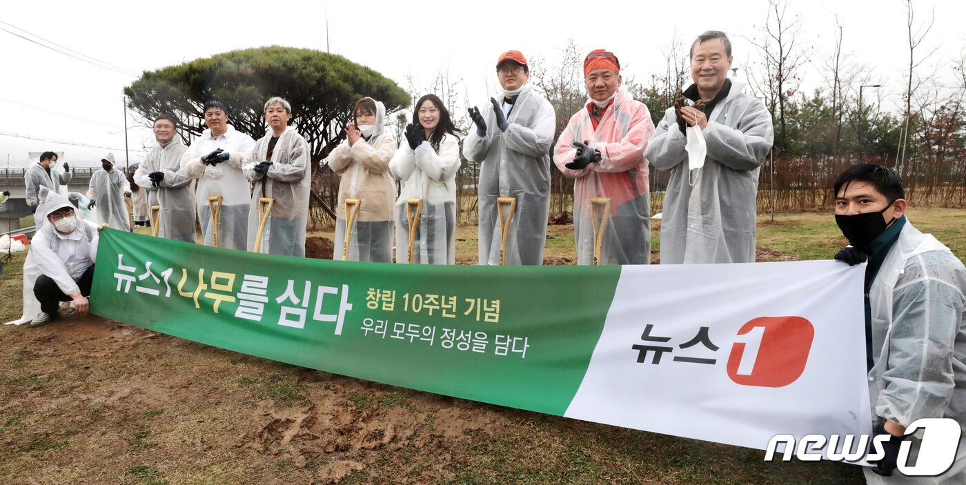 본문 이미지 -  뉴스1이 창립 10주년을 맞아 지난달 3일 오전 고양시 도내동 소재 도래울바람물공원에서 개최한 식목행사에서 홍선근 뉴스1 회장(사진 우측에서 두번째)을 비롯한 참석자들이 기념 촬영을 하고 있다. 탄소줄이기에 동참하는 의미도 있었던 이날 행사에서 홍 회장과 뉴스1 구성원들은 고양시청의 지도를 받아 옥매화 120그루, 왕벚꽃 110그루를 식재했다. 사진 오른쪽부터 홍선근 뉴스1 회장, 강호병 전무, 주성호 기자,강수련기자, 장은지 기자, 이영섭 편집국장, 서명훈 산업2부장, 이백규 대표이사. 현수막 든 구성원은 황덕현기자(오른쪽), 김혁동 차장(왼쪽)2021.4.7/뉴스1 ⓒ News1 이성철 기자