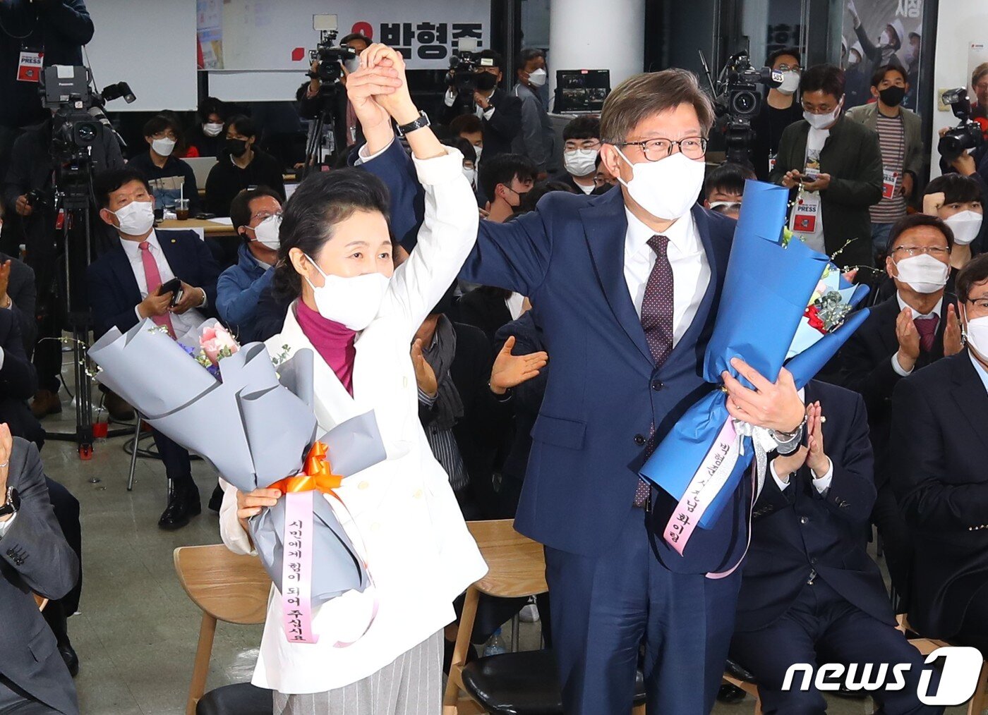 본문 이미지 - 박형준 국민의힘 부산시장 후보가 7일 오후 부산진구 선거사무소에서 4·7재보궐선거 개표방송을 보다 당선이 확실해지자 부인 조현 씨와 꽃다발을 들고 있다. 2021.4.7/뉴스1 ⓒ News1 안은나 기자