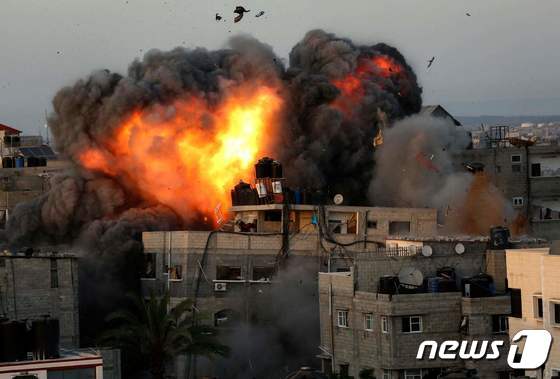 가자지구 팔레스타인 민간인 거주 지역 건물이 2021년 5월 16일 이스라엘군의 공습으로 불타는 모습.  © AFP=뉴스1