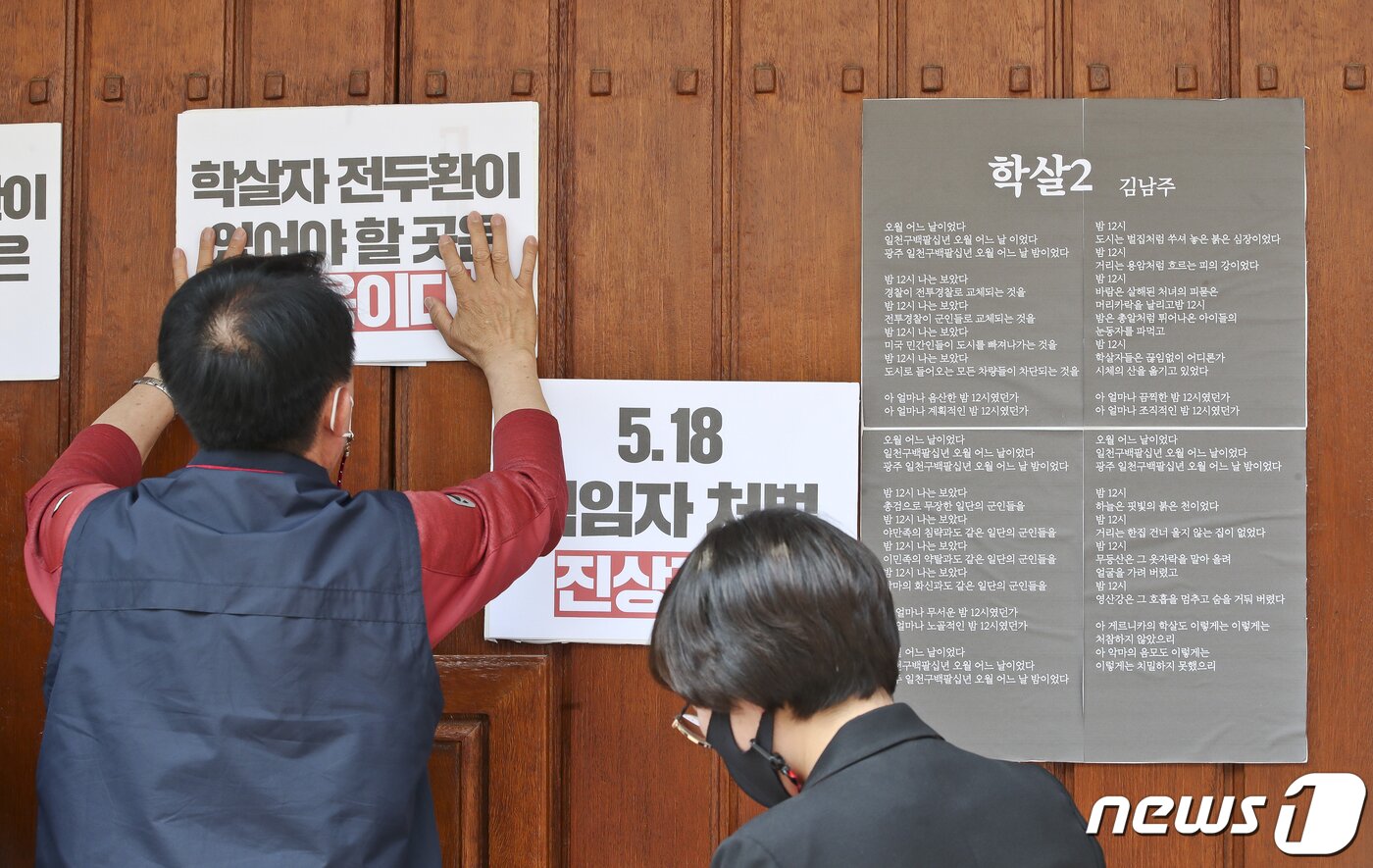 본문 이미지 - 제41주년 5.18 민주화운동 기념일인 18일 오후 서울 서대문구 연희동 전두환 자택에서 서대문구 지역 시민사회단체 회원들이 김남주 시인의 시 '학살2'와 규탄 피켓을 부착하고 있다. 이들은 하루 속히 진상규명과 책임자 처벌이 이뤄져야 하며 전두환은 궁궐같은 저택이 아닌 감옥에 가야 한다고 촉구했다. 2021.5.18/뉴스1 ⓒ News1 신웅수 기자