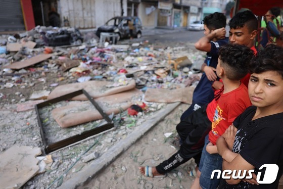 가자지구 팔레스타인 정착촌에 남은 이스라엘의 공격 잔해를 2021년 5월19일 팔레스타인 아이들이 바라보고 있는 모습. © AFP=뉴스1