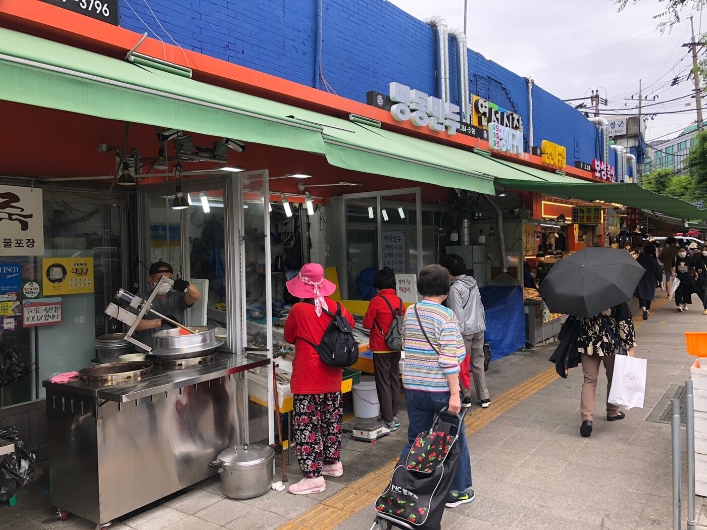 본문 이미지 - 연서시장 바깥에 위치한 상점들의 모습. 인근에 위차힌 노점상들이 사라지면서 사람들이 여유있게 보도블럭을 거닐고 있다. ⓒ 뉴스1 문대현 기자