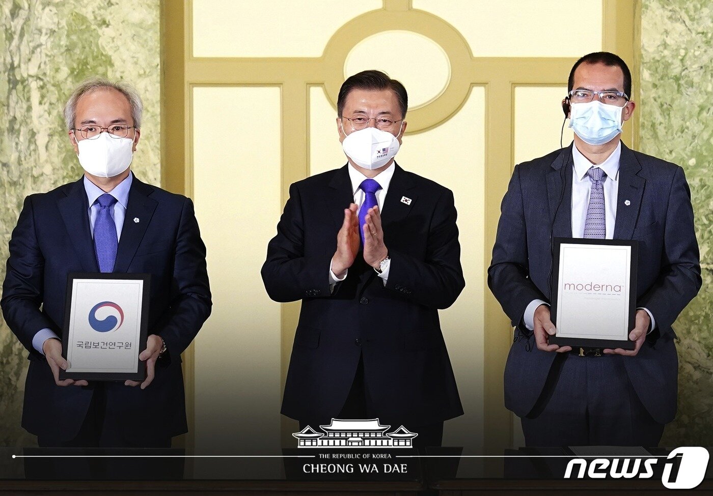 본문 이미지 - 22일 오전(현지시간) 워싱턴 한 호텔에서 열린 '한미 백신 기업 파트너십 행사'에서 문재인 대통령이 참석한 가운데 백신 연구 개발 협력 MOU가 진행되고 있다. 왼쪽부터 권준욱 국립보건연구원장, 문 대통령, 스테판 반셀 모더나 CEO. (청와대 페이스북) 2021.5.23/뉴스1