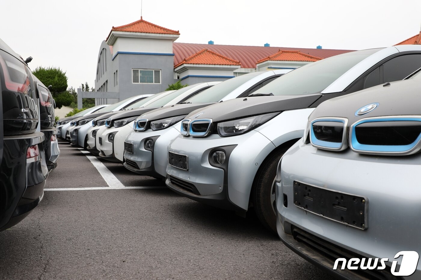 본문 이미지 - 26일 오전 제주 서귀포에 있는 폐관한 공연장의 주차장에 BMW i3 100여 대가 세워져 있다. 지난해 폐업한 렌터카업체 소유였던 이 차량들은 제주시 애월읍 목초지에 세워져있다가 옮겨졌다.2021.5.26/뉴스1ⓒ News1 홍수영 기자