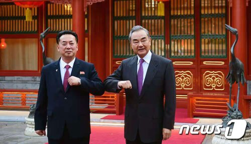 본문 이미지 - 리룡남 중국주재 북한대사(왼쪽)와 왕이 중국 외교담당 국무위원 겸 외교부장. (중국 외교부) ⓒ 뉴스1