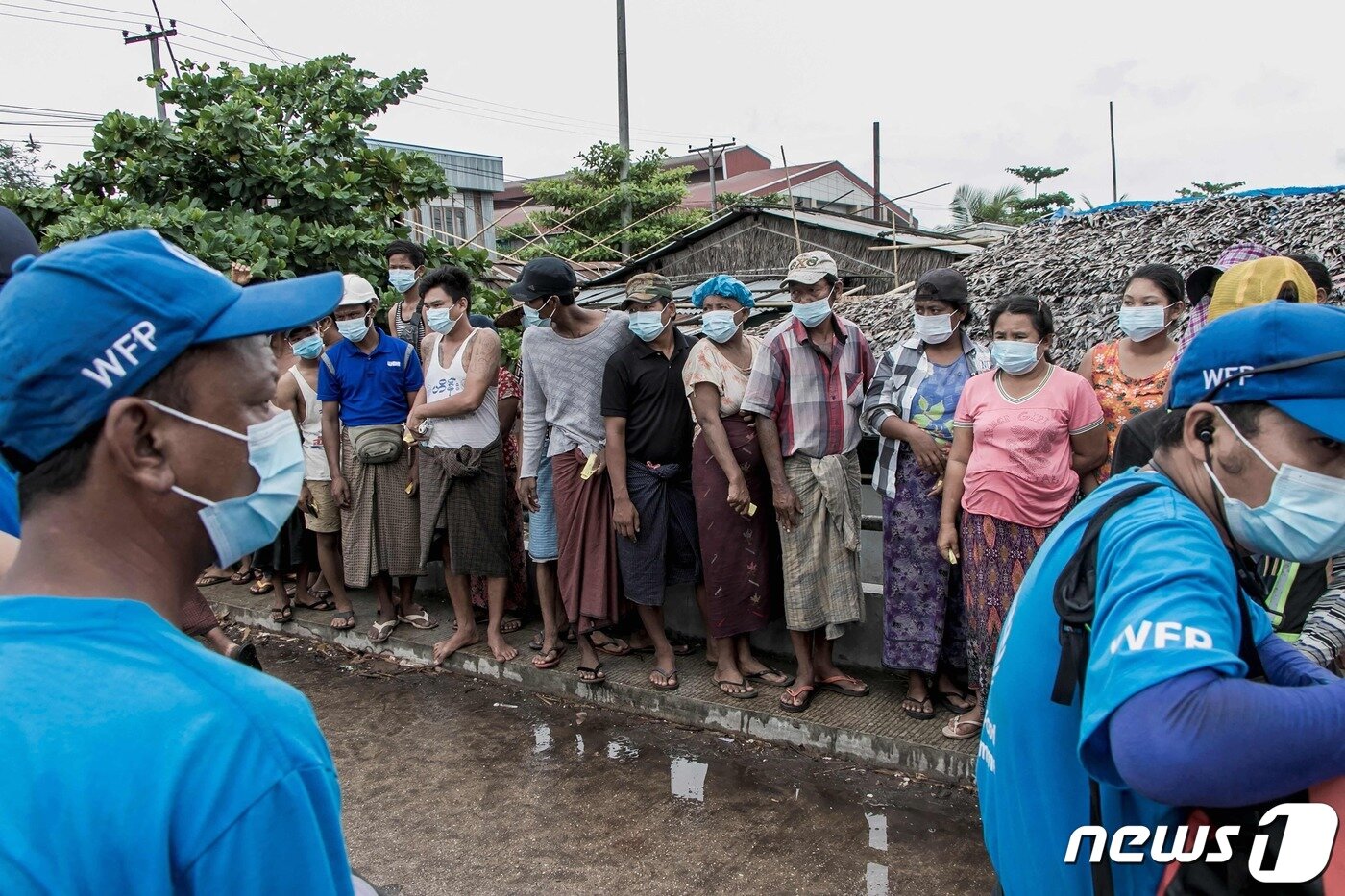 본문 이미지 - 미얀마 양곤 외곽 빈민가에서 2021년 5월 21일 유엔세계식량계획(WFP) 직원들이 주민들에게 쌀을 배급하는 모습. WFP는 코로나19 확산 가운데 발발한 군사 쿠데타 혼란으로 앞으로 몇 달 안에 미얀마인 수백만 명이 기근에 빠질 수 있다고 경고하고 있다. ⓒ AFP=뉴스1 ⓒ News1 최서윤 기자