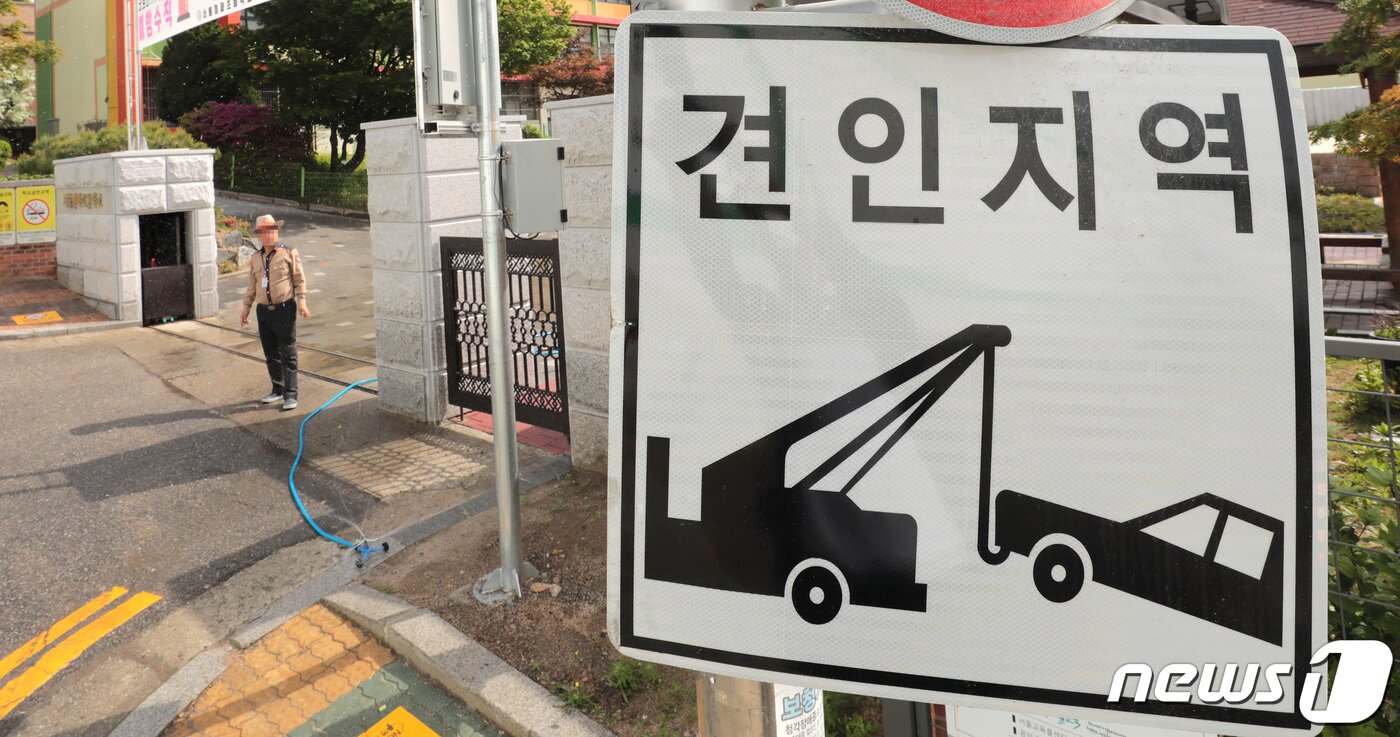본문 이미지 - 오는 11일부터 어린이보호구역(스쿨존) 내 불법 주정차 위반 과태료가 상향된다. 승용차는 기존 8만원에서 12만원으로, 승합차는 9만원에서 13만원으로 오른다. 6일 서울의 한 초등학교 앞에 견인지역 안내문이 붙어 있다. 2021.5.6/뉴스1 ⓒ News1 이성철 기자
