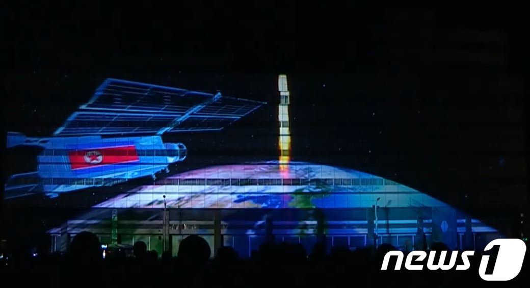 본문 이미지 - 북한이 지난 4월15일 '태양절'(김일성 주석 생일)을 맞아 평양 시내에서 개최한 '빛의 조화-2021' 행사 때 공개한 프로젝션 매핑 영상 중 미사일 발사 및 인공위성 컴퓨터 그래픽 영상 (유튜브 캡처) ⓒ 뉴스1