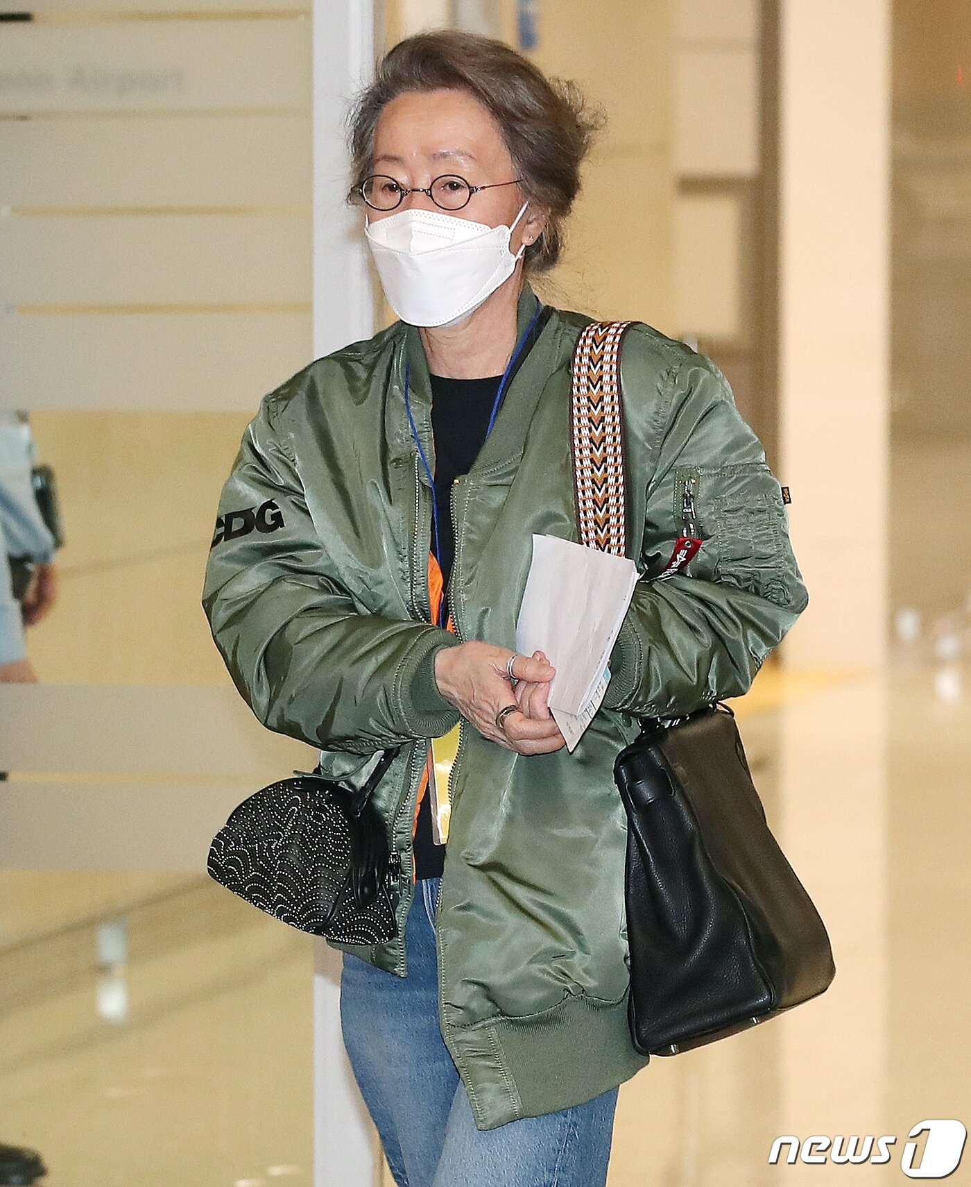 본문 이미지 - 윤여정의 입국 패션도 화제를 모았다. 그녀는 청바지에 아카데미 시상식장 백스테이지에서 입었던 카키색 항공점퍼, 볼드한 반지를 끼고 검은색 미니백, 에르메스의 켈리백을 착용해 눈길을 끌었다. 2021.5.8/뉴스1 ⓒ News1 김진환 기자